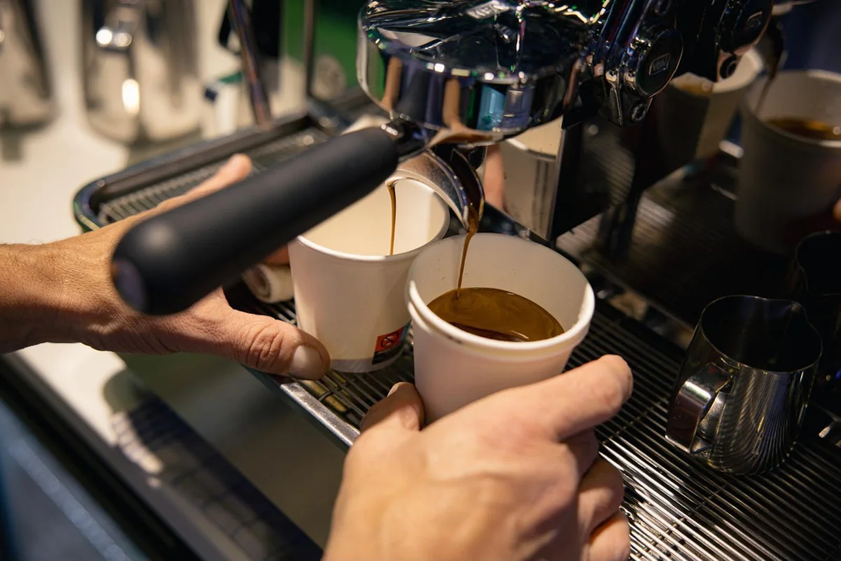 Frisch extrahierter Espresso wird an der Siebträgermaschine in zwei Tassen zubereitet