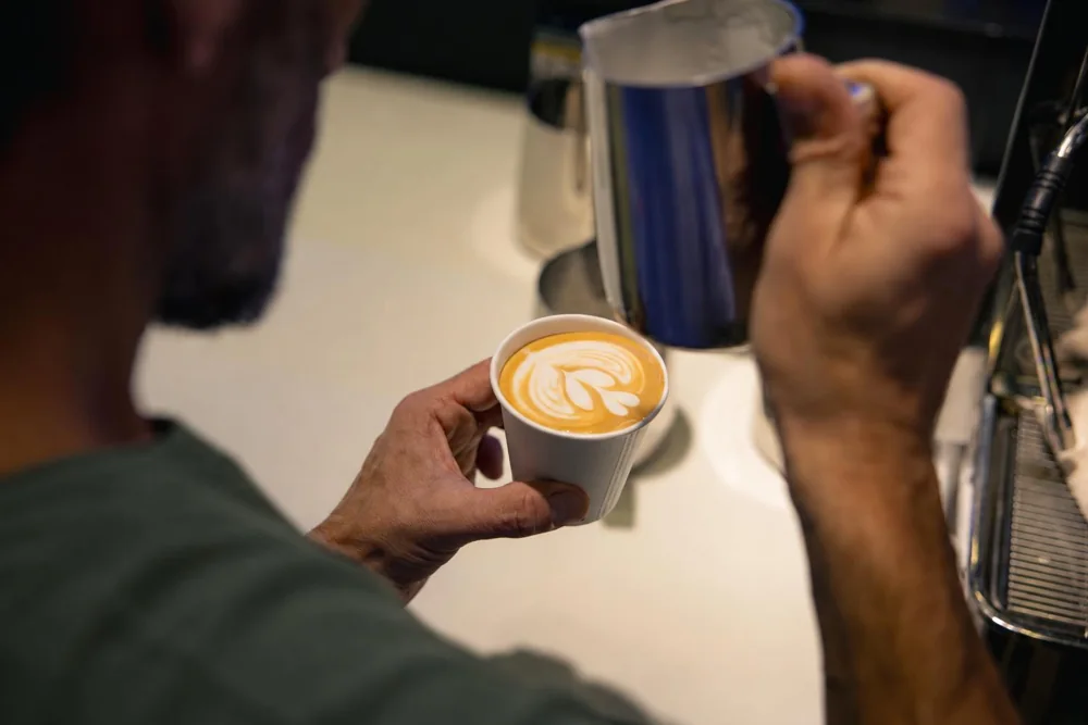 Von Hand gegossene Latte Art in einem frisch zubereiteten Cappuccino