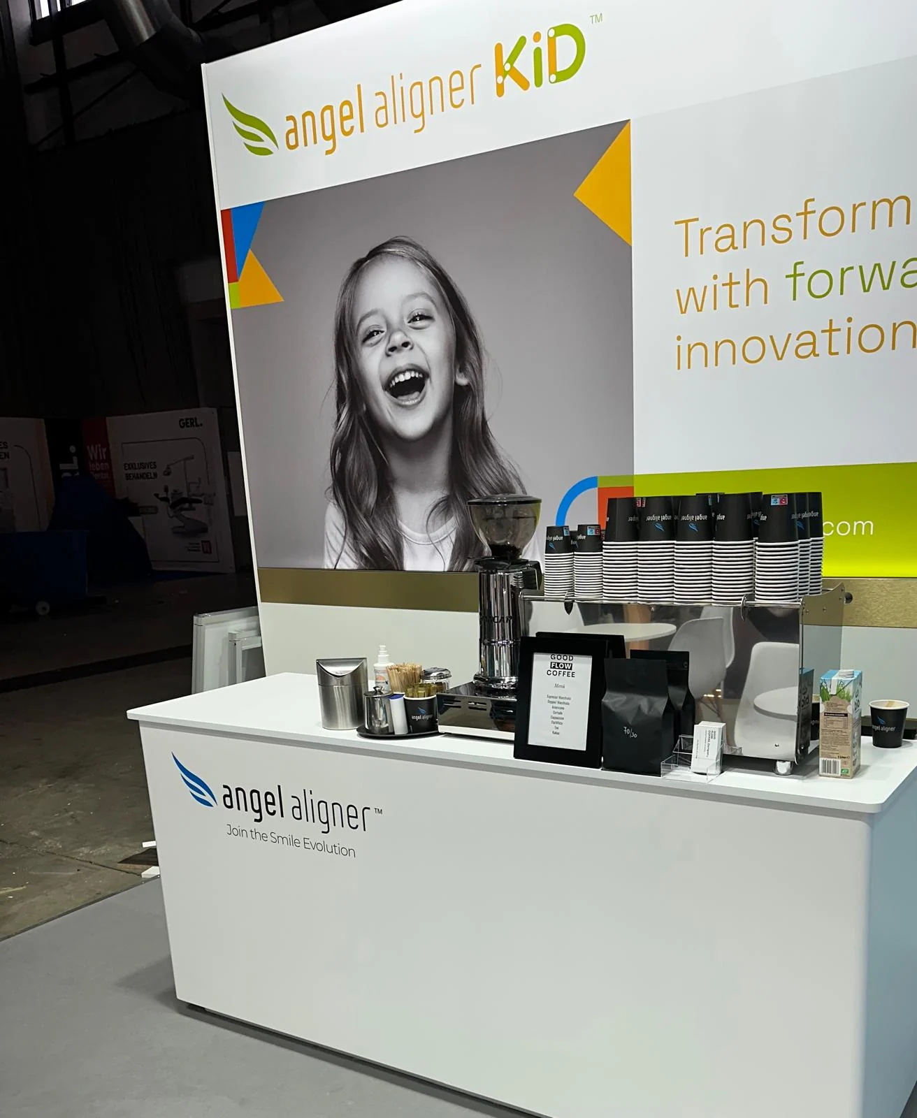 Mobile Kaffeebar am angelaligner-Messestand mit gebrandeter Thekenfront und bedruckten Bechern